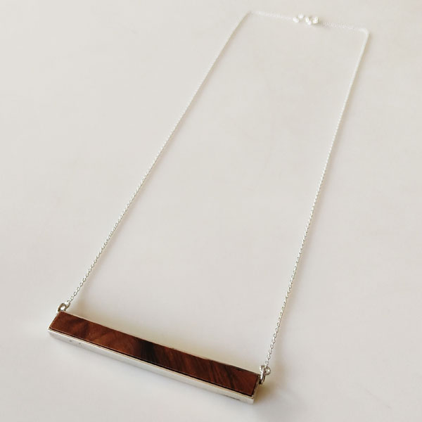 Cadena plateada con colgante de barra de madera, accesorio de moda para mujeres modernas, perfecta para looks casuales y formales, tendencia en joyería contemporánea.