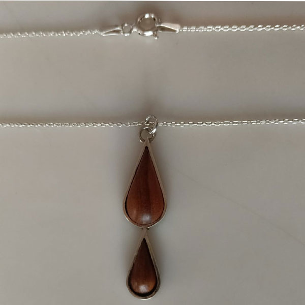 Colgante doble lágrima en plata reciclada con dos piezas de madera de olivo en forma de lágrima, unidas en cadena plateada.