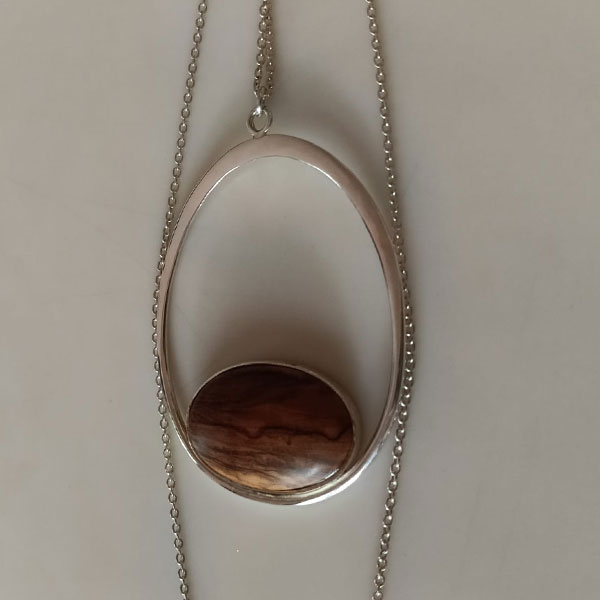 Colgante 011: collar de plata reciclada con un elegante óvalo abierto y piedra de madera de olivo natural en su base.