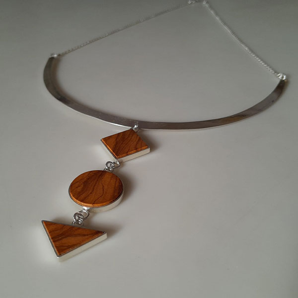 Colgante Tres Formas: collar de plata reciclada con colgantes geométricos de madera de olivo en triángulo, círculo y cuadrado.