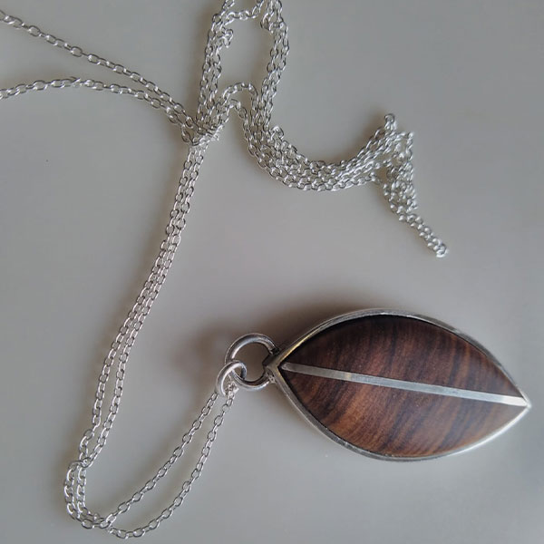 Colgante hoja olivo y plata: collar de plata con colgante artesanal de madera de olivo, detalle de línea diagonal en plata reciclada.